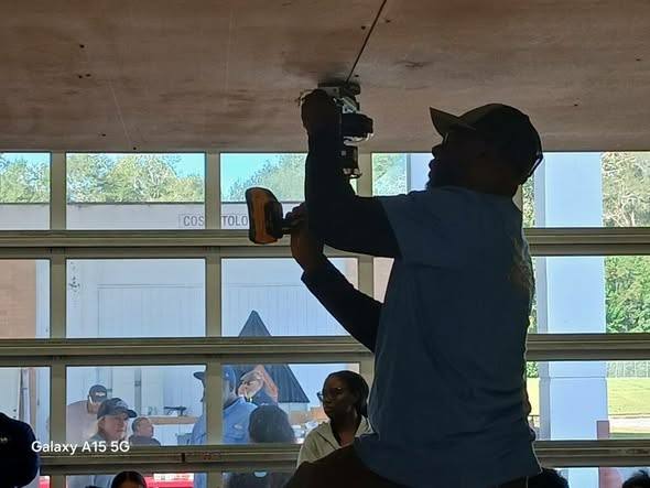A student using a drill overhead during the Future Builders of America Picnic Table Challenge